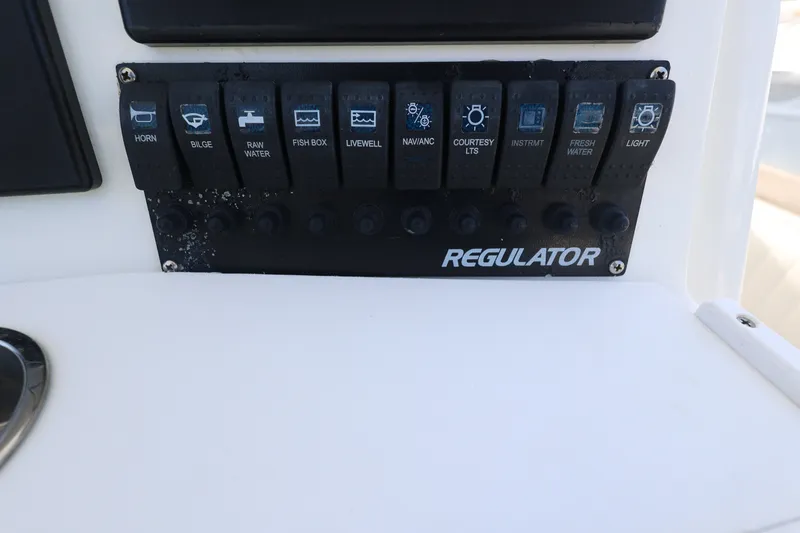 Slide: The Image of Control panel of a 1999 Regulator 26 Forward Seating boat with labeled switches. - 18
