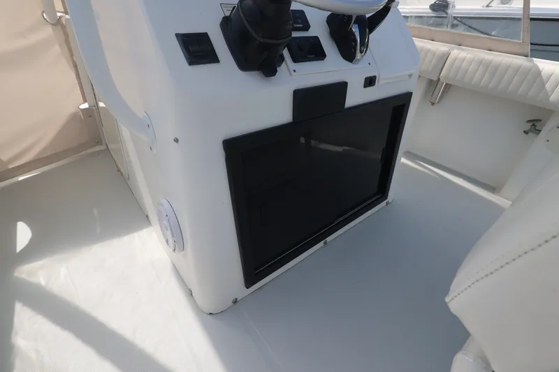 Slide: The Image of 1999 Regulator 26 Forward Seating boat interior with steering console and seating area. - 23