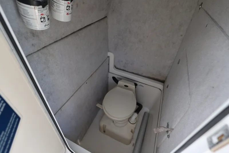 Slide: The Image of 1999 Regulator 26 Forward Seating boat interior with compact marine toilet. - 34
