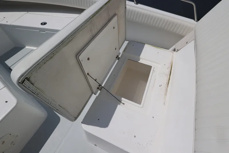 Slide: The Image of An open storage compartment on a white boat with cushioned seating and a clean design. - 32