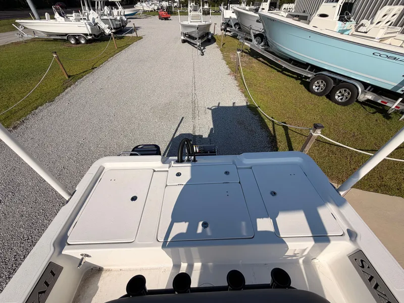 Slide: The Image of The image shows the stern of a Savannah 220 IS boat on a gravel path, surrounded by other boats. - 13