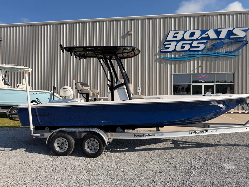 The Image of A blue 2027 Savannah 220 IS boat on a trailer in front of a boat sales shop. - 0