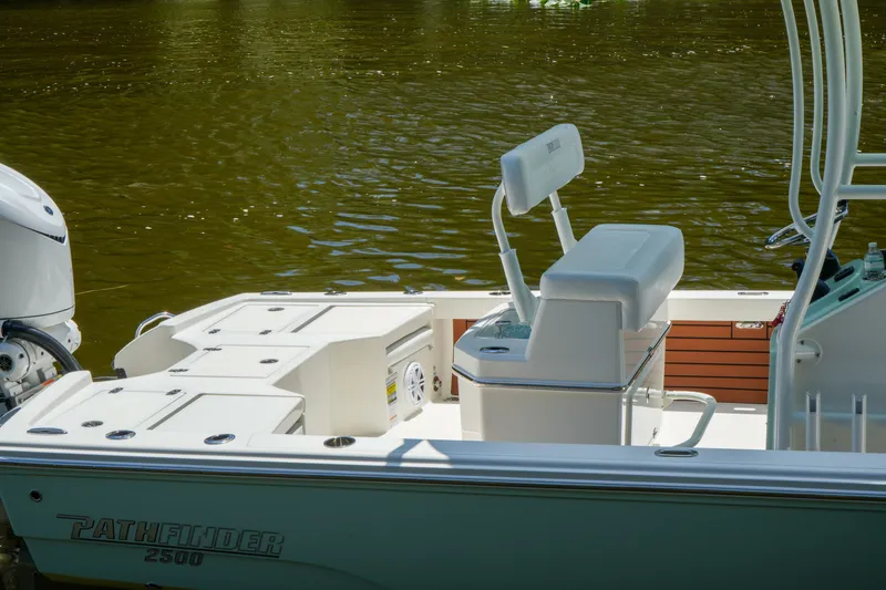 Slide: The Image of 2026 Pathfinder 2500 Tournament boat interior with seating and storage, docked on calm water. - 10
