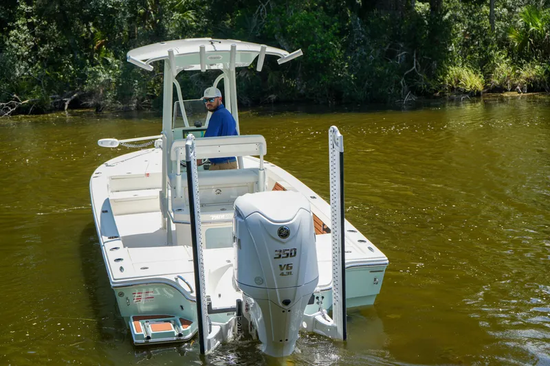 Slide: The Image of 2026 Pathfinder 2500 Tournament boat on a calm river, featuring a powerful outboard motor. - 22