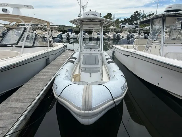 Slide: The Image of A 2022 Ribcraft 6.5 docked, surrounded by other boats. - 1