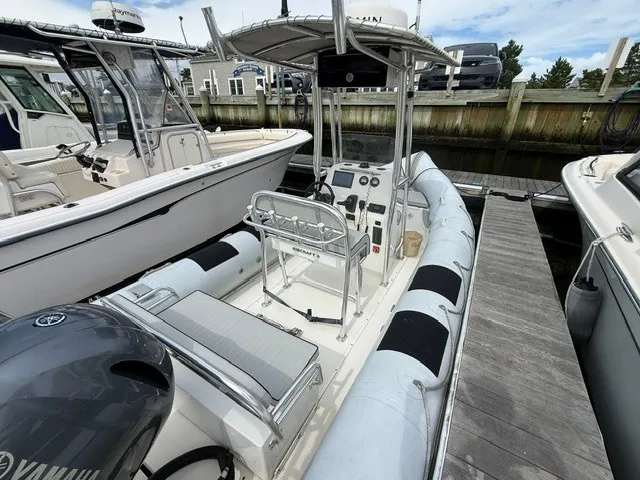 Slide: The Image of A 2022 Ribcraft 6.5 at a dock, featuring an open cockpit and a T-top. - 5