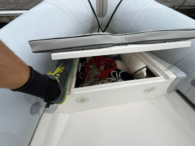Slide: The Image of An open storage compartment in a Ribcraft 6.5 boat with ropes and equipment. - 9