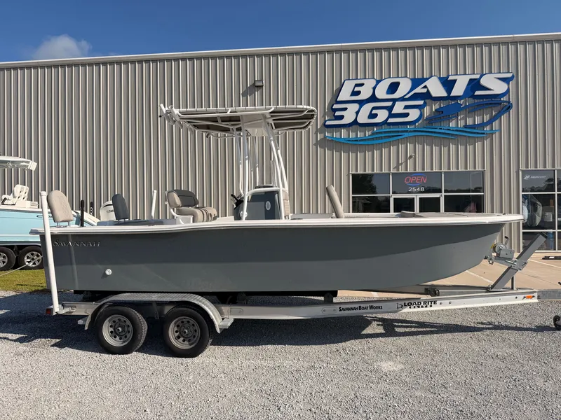 The Image of A gray 2027 Savannah SS21 boat on a trailer in front of a boat dealership. - 0