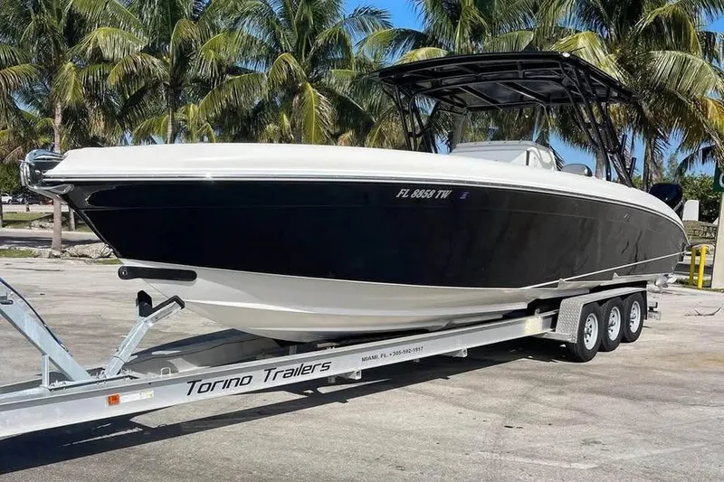 Slide: The Image of 2009 Midnight Express 34 Open boat on trailer, surrounded by palm trees. - 2