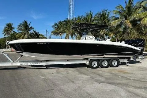 Slide: The Image of 2009 Midnight Express 34 Open boat on trailer, surrounded by palm trees. - 0