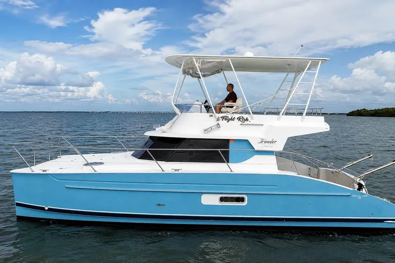 Slide: The Image of 2006 Fountaine Pajot Highland 35 Pilot boat cruising on open water under a cloudy sky. - 1