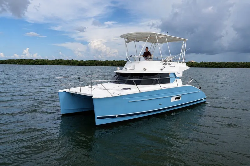 Slide: The Image of 2006 Fountaine Pajot Highland 35 Pilot catamaran cruising on calm waters under a cloudy sky. - 2