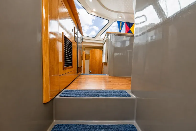 Slide: The Image of Interior view of 2006 Fountaine Pajot Highland 35 Pilot yacht, featuring wooden cabinetry and blue carpeting. - 25