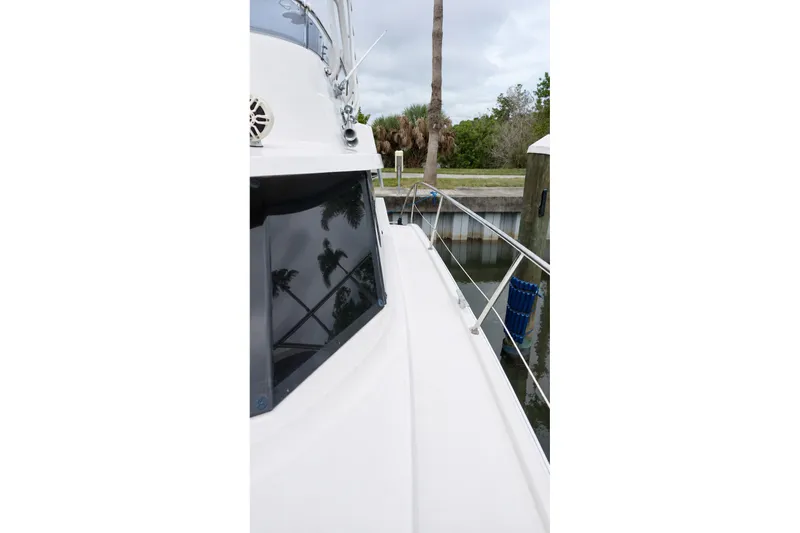 Slide: The Image of 2006 Fountaine Pajot Highland 35 Pilot yacht docked near palm trees. - 10