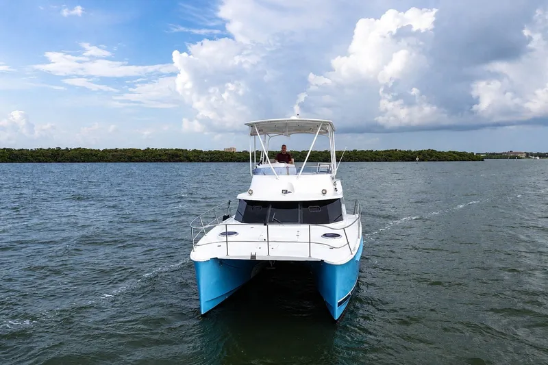 Slide: The Image of 2006 Fountaine Pajot Highland 35 Pilot catamaran cruising on open water under a cloudy sky. - 3