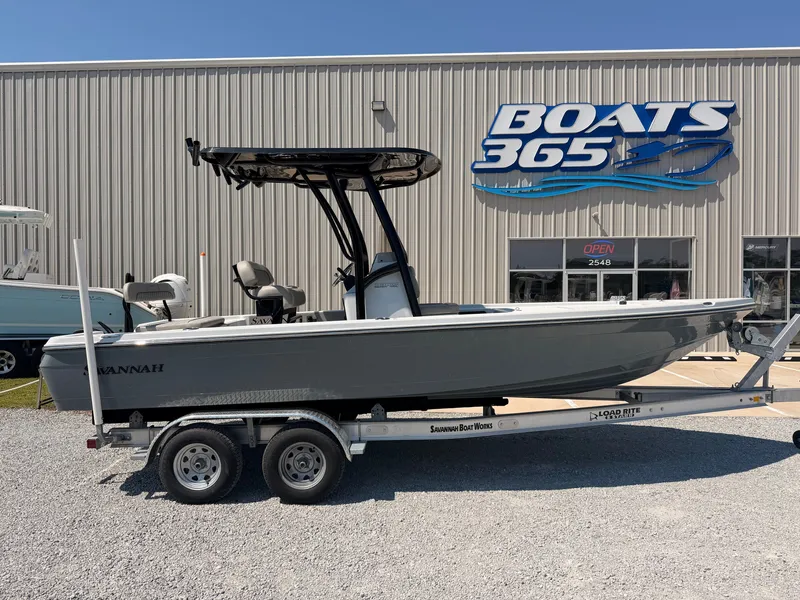 The Image of A gray 2027 Savannah 220 IS boat on a trailer in front of a boat building. - 0