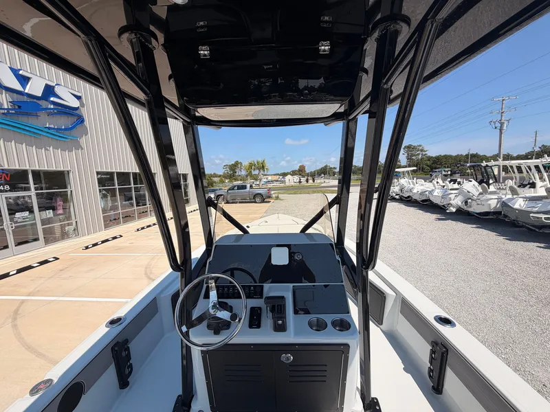 Slide: The Image of The image shows the cockpit of a 2027 Savannah 220 IS boat. It is parked outside a building with other boats in the background. - 7