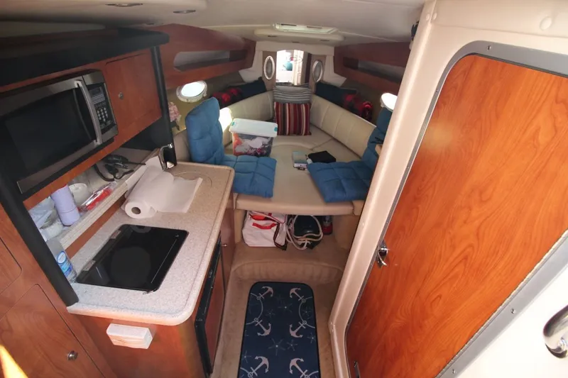 Slide: The Image of Interior of a 2008 Rinker 280 Express Cruiser with kitchenette and seating area. - 16