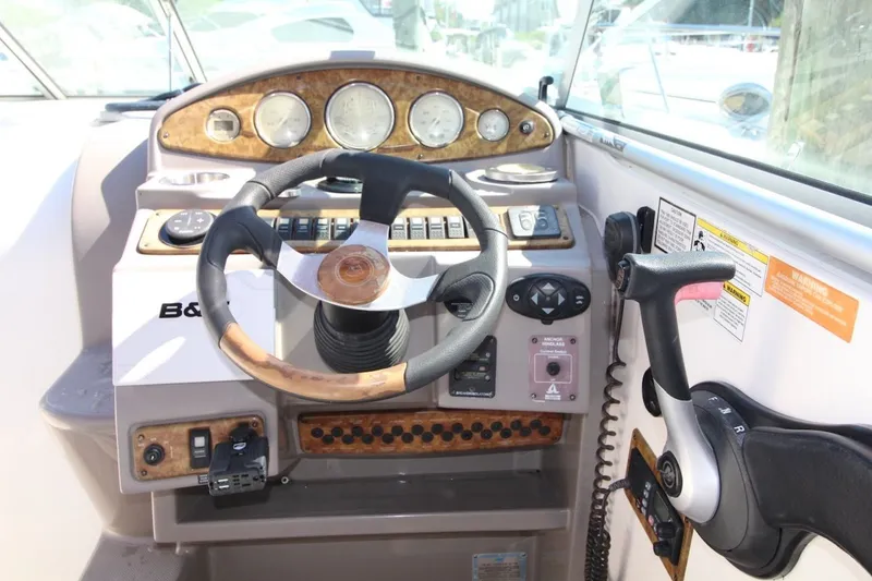 Slide: The Image of 2008 Rinker 280 Express Cruiser helm with steering wheel and control panel. - 15