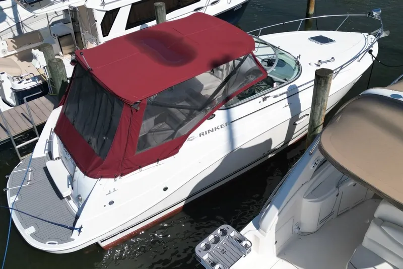 Slide: The Image of 2008 Rinker 280 Express Cruiser with red canopy docked at marina. - 5