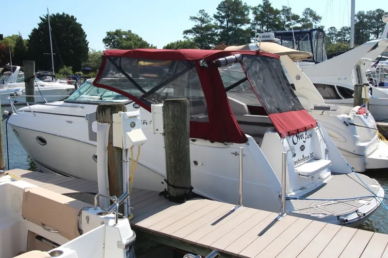 Slide: The Image of 2008 Rinker 280 Express Cruiser docked with red canopy in marina setting. - 1