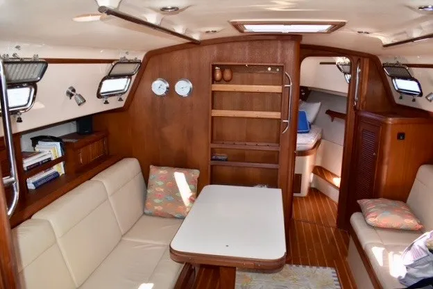 Slide: The Image of Interior of 2004 Island Packet 370 sailboat with cozy seating and wooden cabinetry. - 15