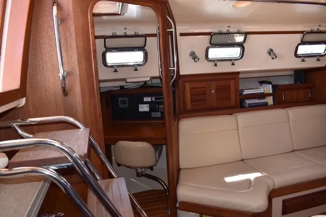 Slide: The Image of Interior of 2004 Island Packet 370 sailboat with cozy seating and wooden cabinetry. - 16