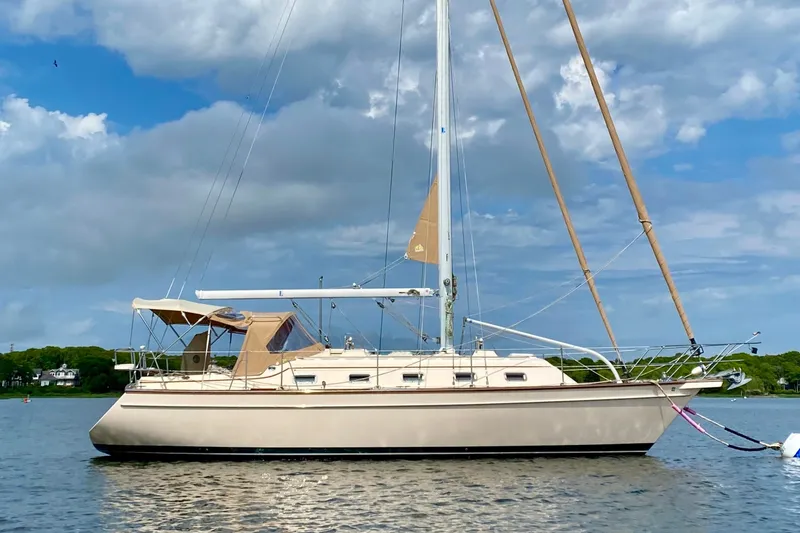 The Image of Island Packet 370 sailboat from 2004 anchored on a calm lake under a cloudy sky. - 0