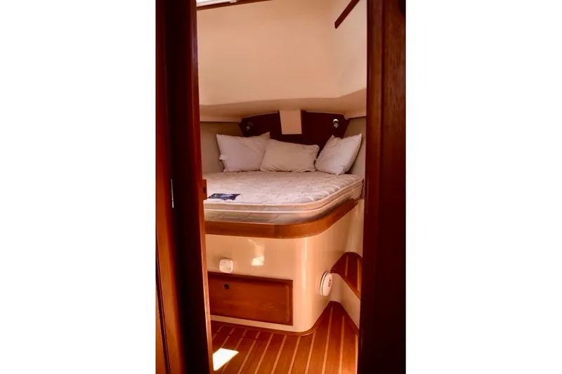 Slide: The Image of Cozy cabin interior of 2004 Island Packet 370 sailboat with bed and wooden accents. - 23