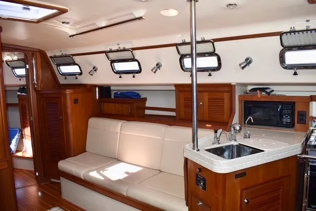 Slide: The Image of Interior of 2004 Island Packet 370 yacht with cozy seating, kitchenette, and porthole windows. - 22