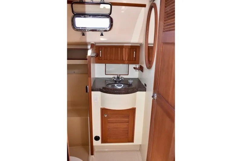 Slide: The Image of 2004 Island Packet 370 yacht bathroom with wooden cabinetry and stainless steel sink. - 20