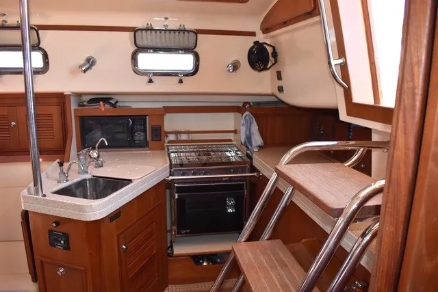 Slide: The Image of Interior of 2004 Island Packet 370 sailboat with kitchen and wooden cabinetry. - 19