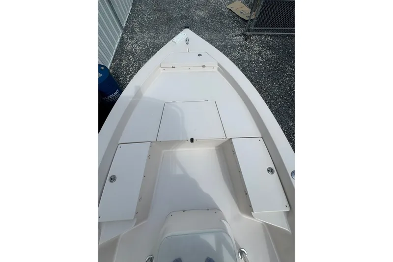 Slide: The Image of 2003 Pathfinder 2200 V boat deck with storage compartments, parked on gravel. - 7