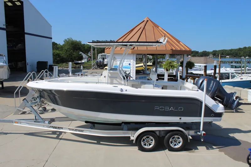 Slide: The Image of A 2015 Robalo R222 Center Console boat on a trailer at a marina. - 2