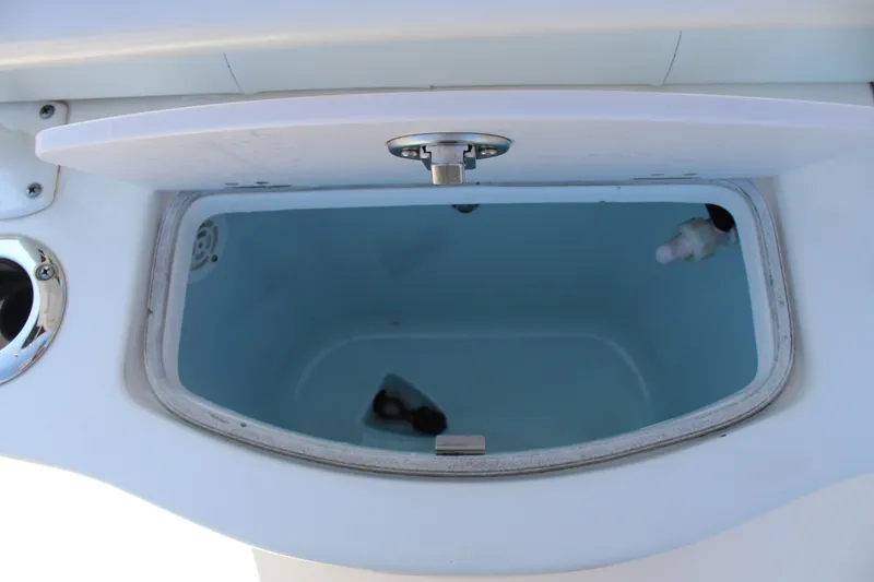 Slide: The Image of An open storage compartment on a 2015 Robalo R222 Center Console boat. - 11