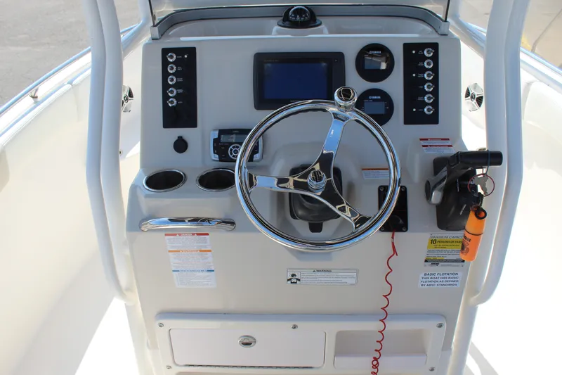 Slide: The Image of The image shows the helm of a 2015 Robalo R222 Center Console boat with modern instruments. - 12