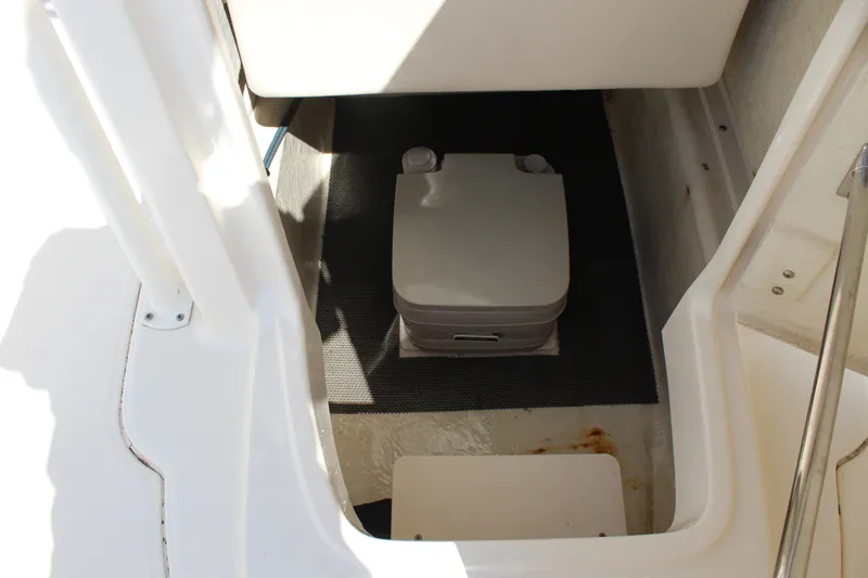 Slide: The Image of The image shows a small toilet inside a boat, surrounded by white walls. - 21