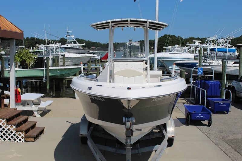 Slide: The Image of A 2015 Robalo R222 Center Console boat on a trailer at a marina. - 1