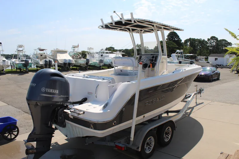 Slide: The Image of A 2015 Robalo R222 Center Console boat on a trailer in a marina area. - 5