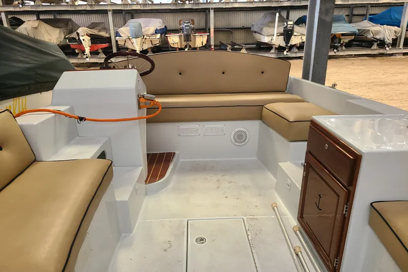 Slide: The Image of Interior of a 2019 Duffy 18 boat with tan seating and wooden accents. - 14