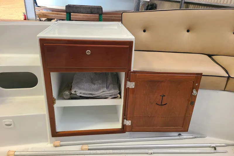 Slide: The Image of Wooden cabinet and beige seating on a 2019 Duffy 18 boat interior. - 16