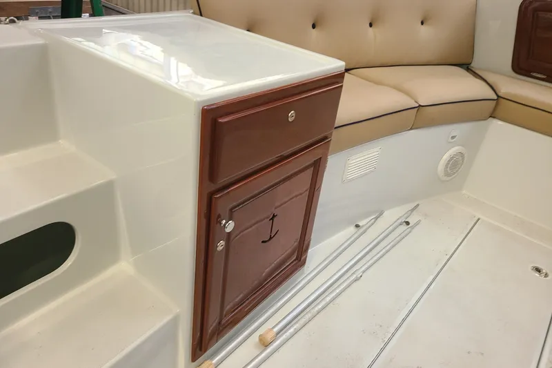 Slide: The Image of Interior of a 2019 Duffy 18 boat with cushioned seating and wooden storage cabinet. - 15