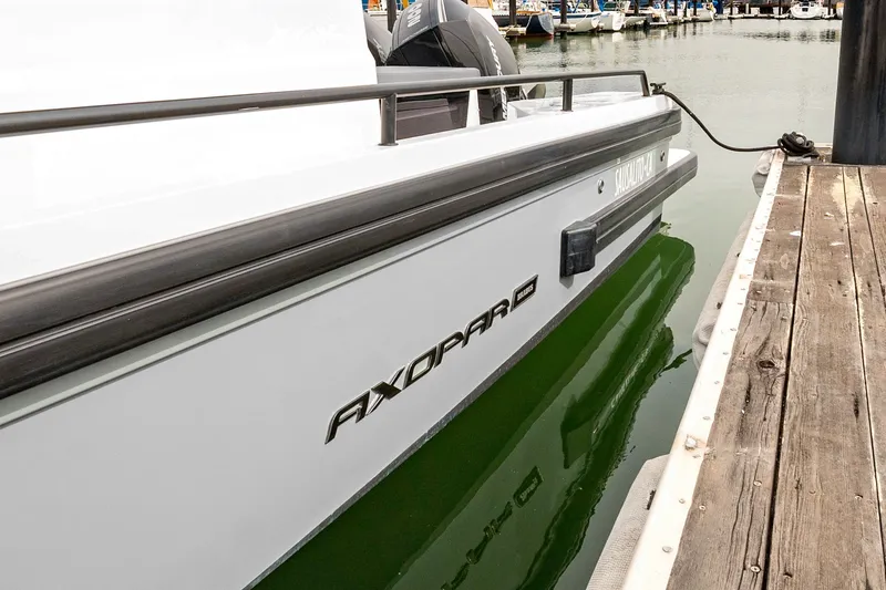 Slide: The Image of 2021 Axopar 28 Cabin boat docked at marina, side view. - 37