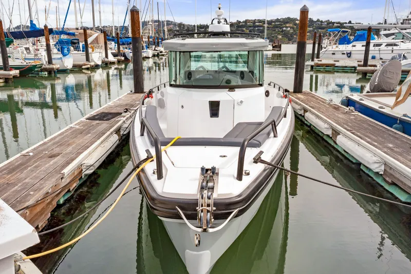 Slide: The Image of 2021 Axopar 28 Cabin boat docked in a marina, surrounded by other vessels. - 5