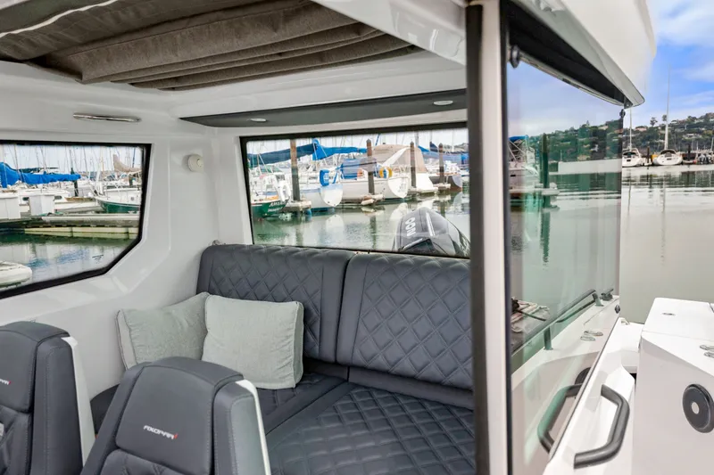 Slide: The Image of Interior of 2021 Axopar 28 Cabin boat with comfortable seating and marina view. - 15