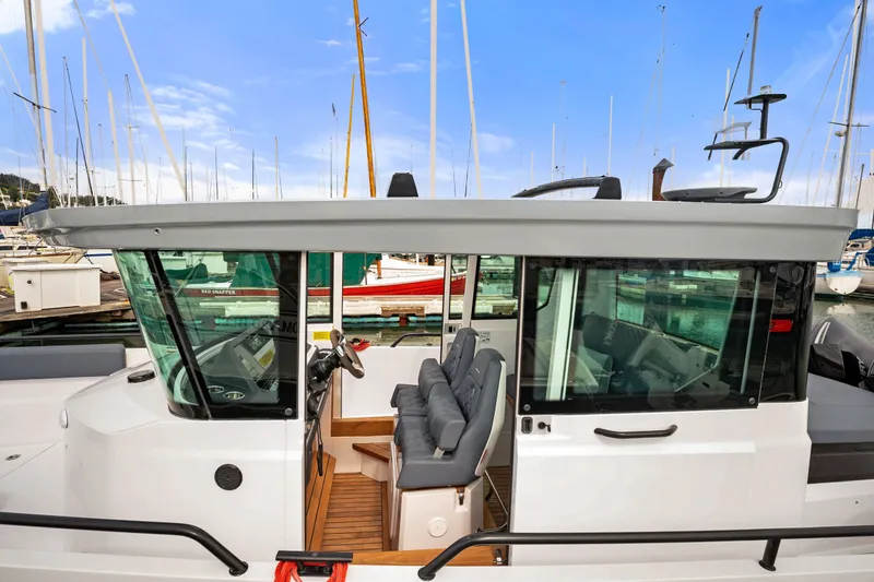 Slide: The Image of 2021 Axopar 28 Cabin boat with sleek design, docked in a marina. - 6