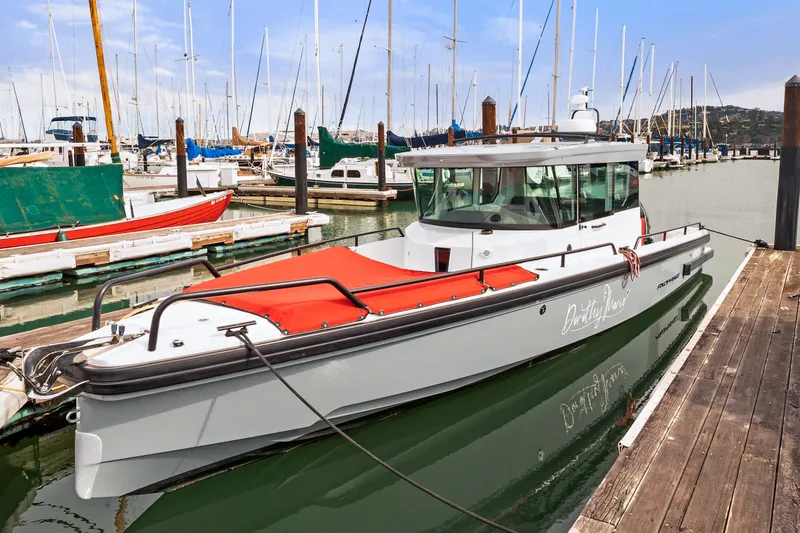 Slide: The Image of 2021 Axopar 28 Cabin boat docked in a marina with sailboats in the background. - 41