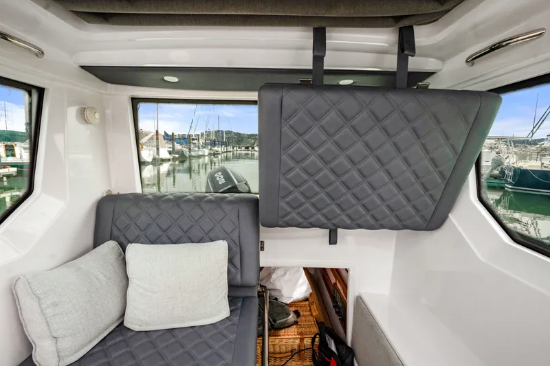 Slide: The Image of Interior of 2021 Axopar 28 Cabin with quilted seating and marina view. - 27