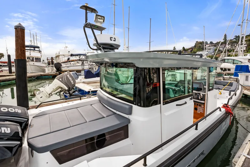 Slide: The Image of 2021 Axopar 28 Cabin boat docked in a marina, showcasing sleek design and modern features. - 1