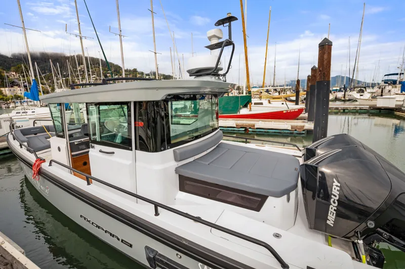 Slide: The Image of 2021 Axopar 28 Cabin boat docked in a marina with Mercury engine. - 7